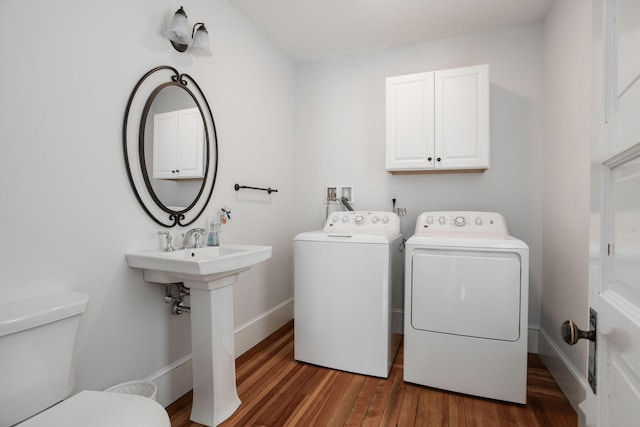 laundry area with separate washer and dryer, sink, and dark hardwood / wood-style flooring