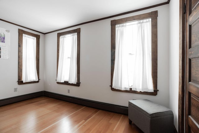 spare room featuring crown molding and light hardwood / wood-style floors