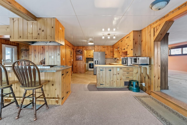 kitchen featuring sink, a breakfast bar area, kitchen peninsula, and appliances with stainless steel finishes