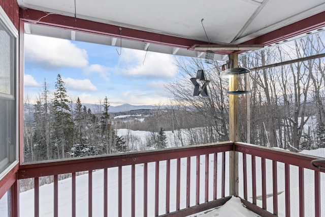 snow covered deck with a mountain view