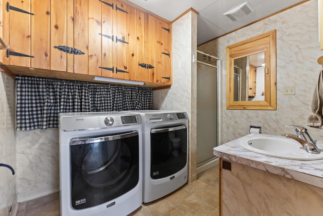 clothes washing area with sink, crown molding, and washer and clothes dryer