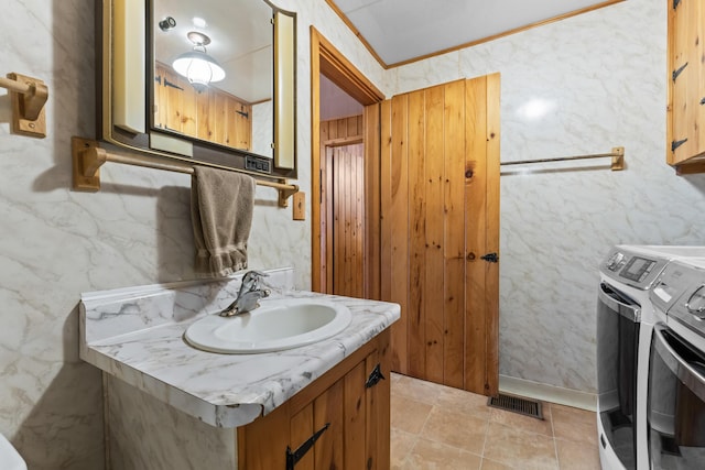 bathroom with crown molding, vanity, and washer and dryer