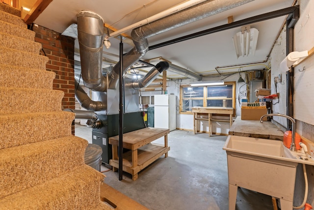 basement with white refrigerator and sink