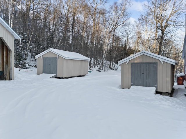 snowy yard featuring a shed