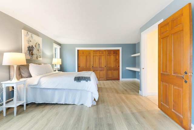 bedroom featuring a closet, baseboards, and light wood-type flooring