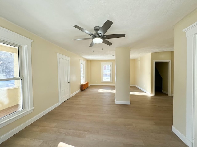 interior space with a textured ceiling, light hardwood / wood-style floors, and ceiling fan