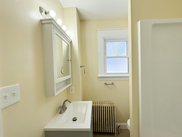 bathroom with vanity, radiator heating unit, and toilet