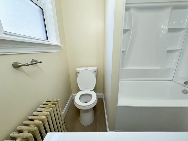 bathroom featuring wood-type flooring, toilet, and radiator