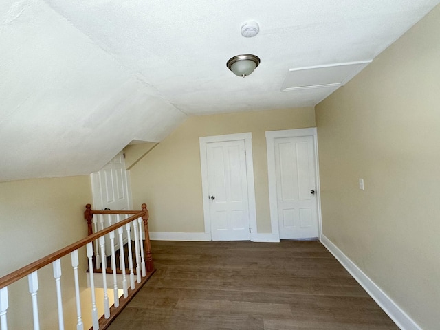 additional living space with dark wood-type flooring and vaulted ceiling