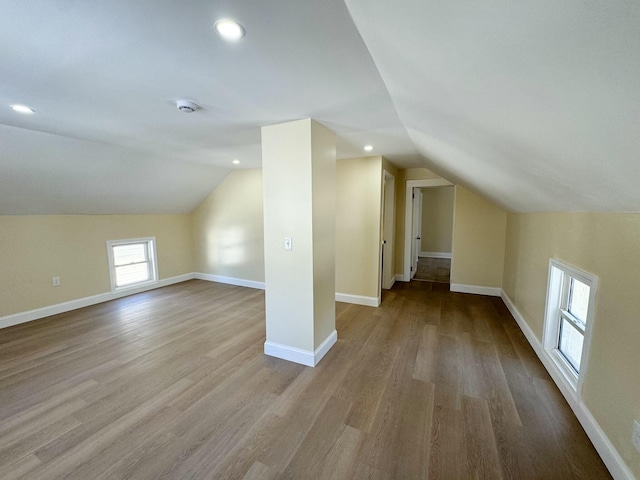 additional living space featuring lofted ceiling and light hardwood / wood-style flooring