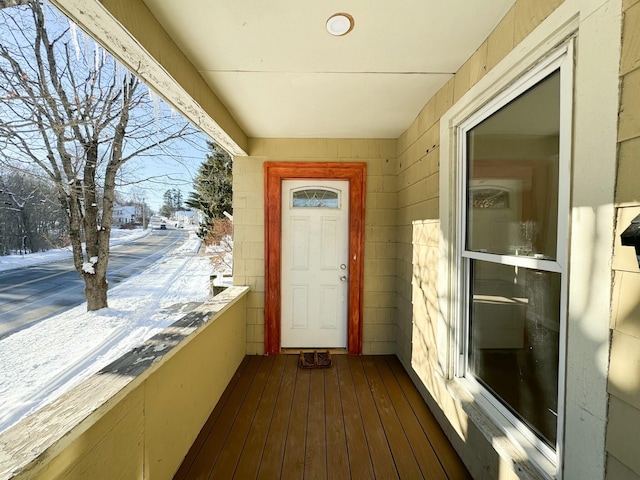 snow covered property entrance featuring a balcony