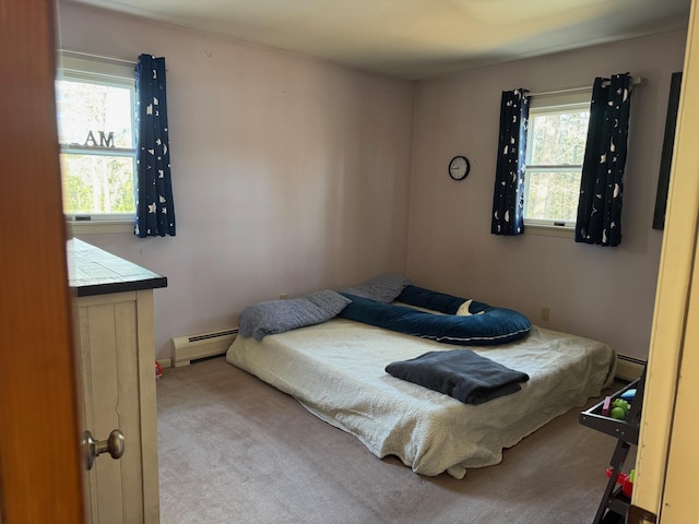 bedroom with a baseboard heating unit and multiple windows