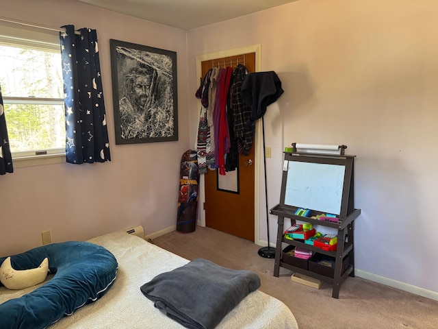 bedroom featuring baseboards and carpet