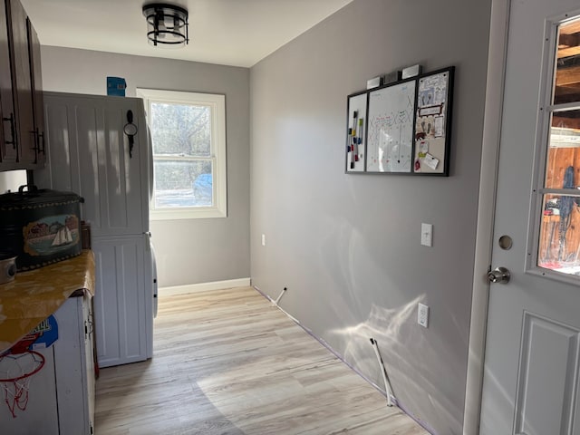 entryway with light wood-style floors and baseboards