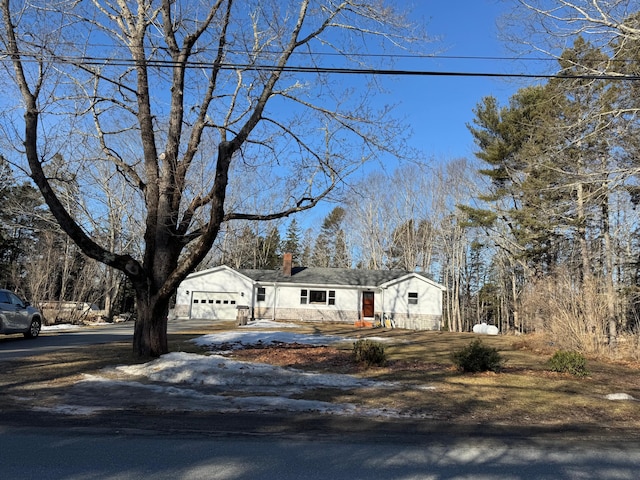 view of front of property with driveway, an attached garage, and a chimney