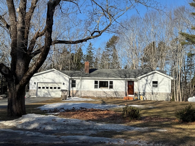 single story home with a garage, driveway, and a chimney