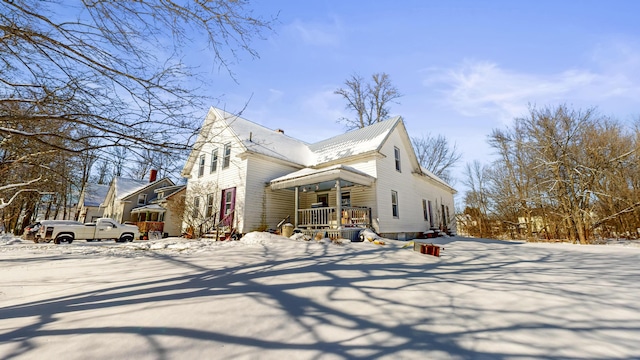 view of snowy exterior featuring covered porch