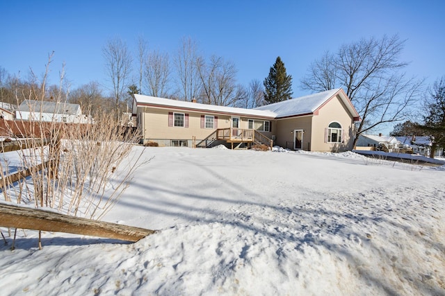 snow covered rear of property featuring a wooden deck