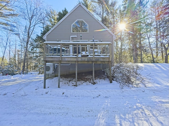 snow covered house with ac unit and a deck