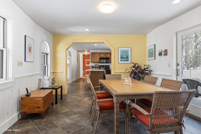16 Hanna Ln, Bristol, ME 04539 - dining area with arched walkways, recessed lighting, wainscoting, dark stone finish floors, and baseboards