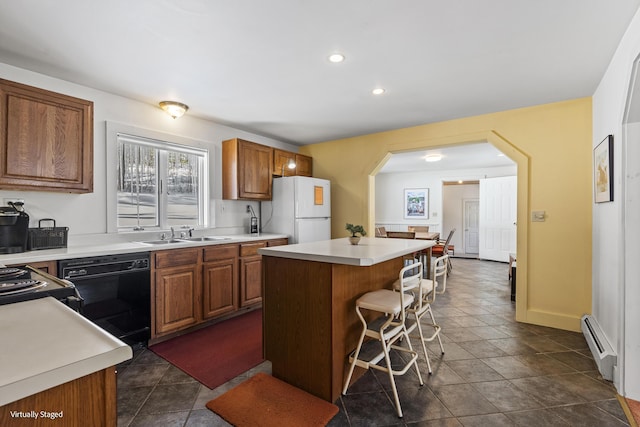 16 Hanna Ln, Bristol, ME 04539 - kitchen featuring freestanding refrigerator, a baseboard radiator, black dishwasher, a sink, and arched walkways
