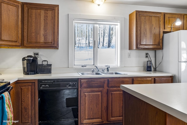 16 Hanna Ln, Bristol, ME 04539 - kitchen with dishwasher, a sink, freestanding refrigerator, brown cabinetry, and light countertops