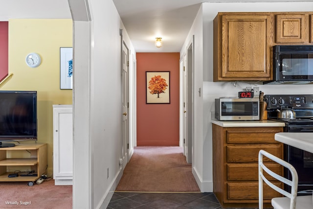 16 Hanna Ln, Bristol, ME 04539 - kitchen with black appliances, dark colored carpet, brown cabinets, light countertops, and baseboards