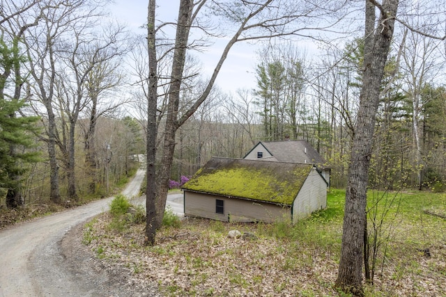16 Hanna Ln, Bristol, ME 04539 - view of side of property featuring dirt driveway, roof with shingles, and a view of trees