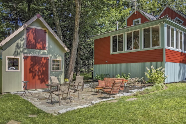 exterior space featuring an outdoor living space, an outdoor structure, a patio area, and a lawn