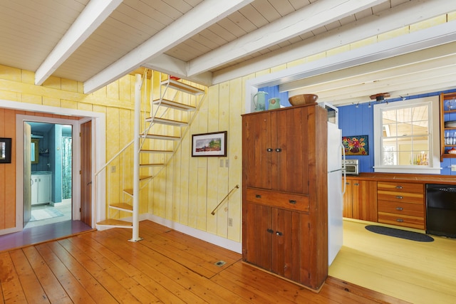 interior space with beamed ceiling, hardwood / wood-style flooring, and wooden walls