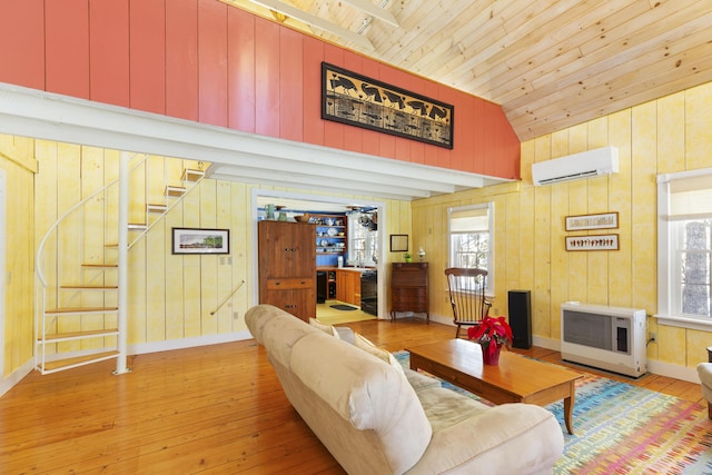 living room with an AC wall unit, a healthy amount of sunlight, heating unit, and light hardwood / wood-style flooring