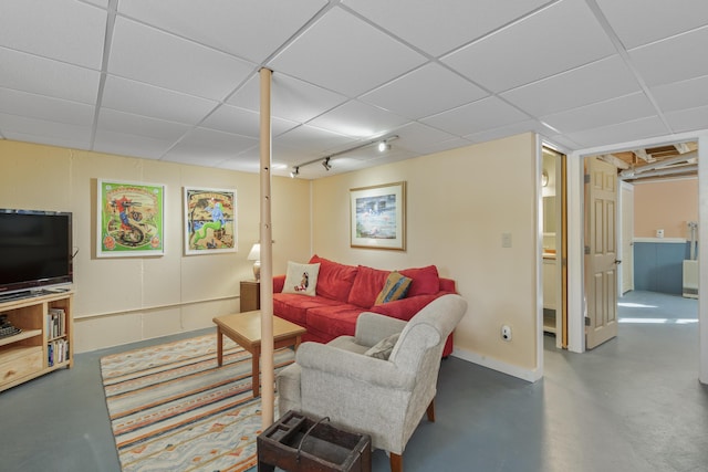 living room featuring concrete flooring and a drop ceiling