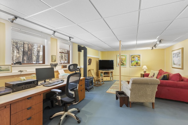 office space featuring a drop ceiling, rail lighting, and concrete floors