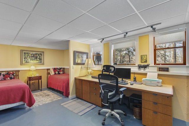 bedroom featuring a paneled ceiling and concrete floors