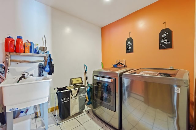 laundry room featuring washer and clothes dryer and light tile patterned flooring