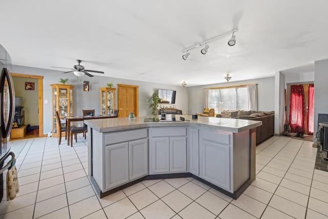 kitchen featuring gray cabinets, black electric stovetop, light tile patterned floors, and ceiling fan