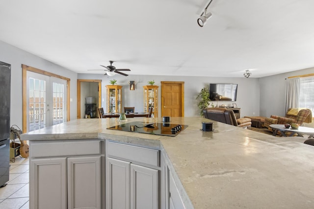 kitchen with rail lighting, light tile patterned floors, ceiling fan, black electric cooktop, and french doors