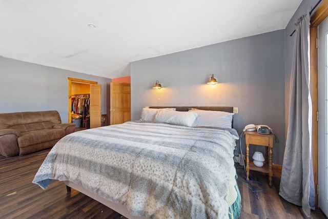 bedroom featuring a closet, a walk in closet, and dark hardwood / wood-style floors