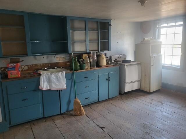 kitchen featuring open shelves, blue cabinetry, and range