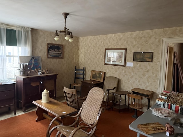 sitting room with an inviting chandelier and wallpapered walls