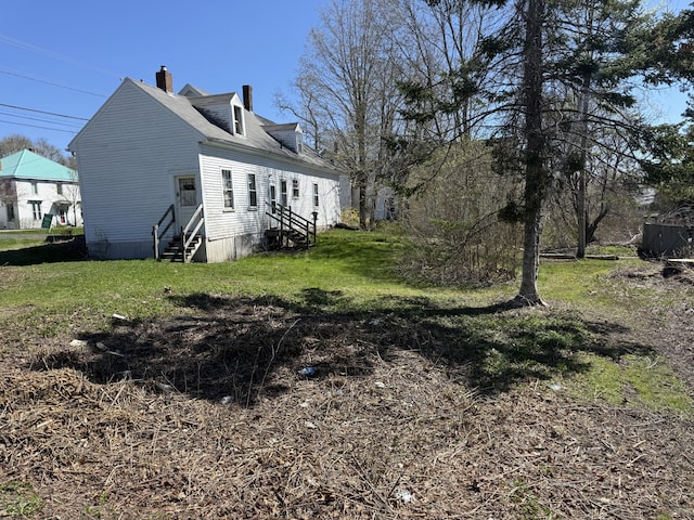 52 Main St, Thomaston, ME 04861 - view of home's exterior with a yard, a chimney, and entry steps