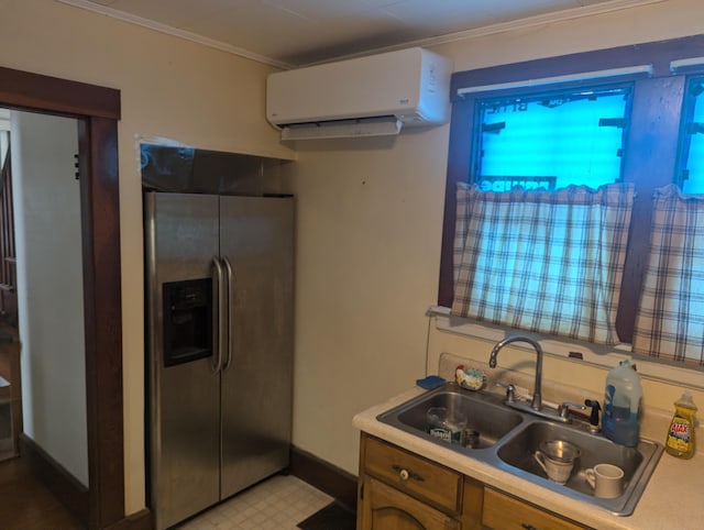 kitchen with ornamental molding, sink, a wall mounted AC, and stainless steel fridge with ice dispenser