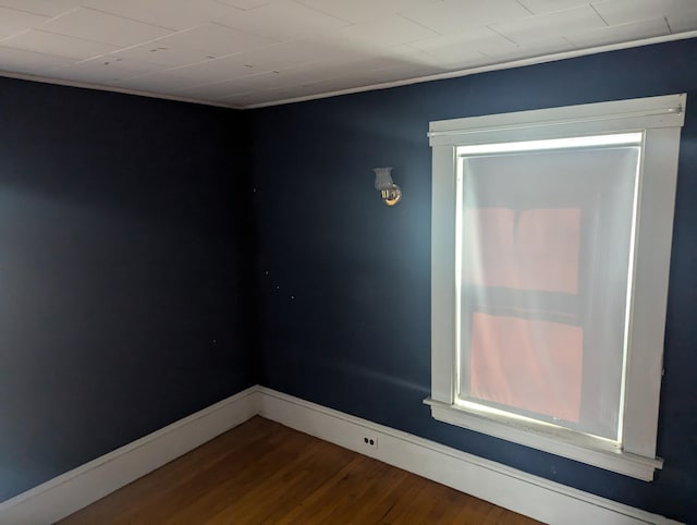 unfurnished room featuring wood finished floors and baseboards