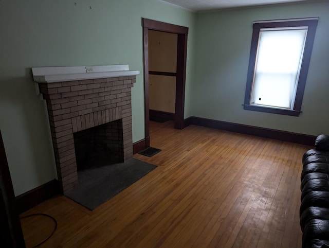 unfurnished living room featuring visible vents, a fireplace, baseboards, and hardwood / wood-style floors