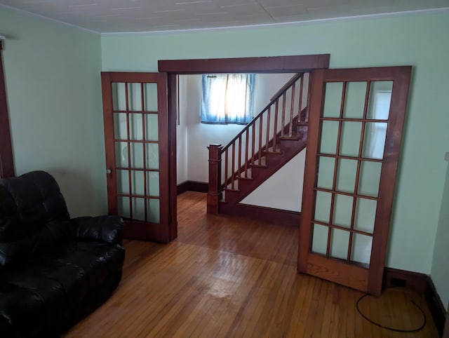 interior space featuring stairs, crown molding, hardwood / wood-style flooring, and baseboards