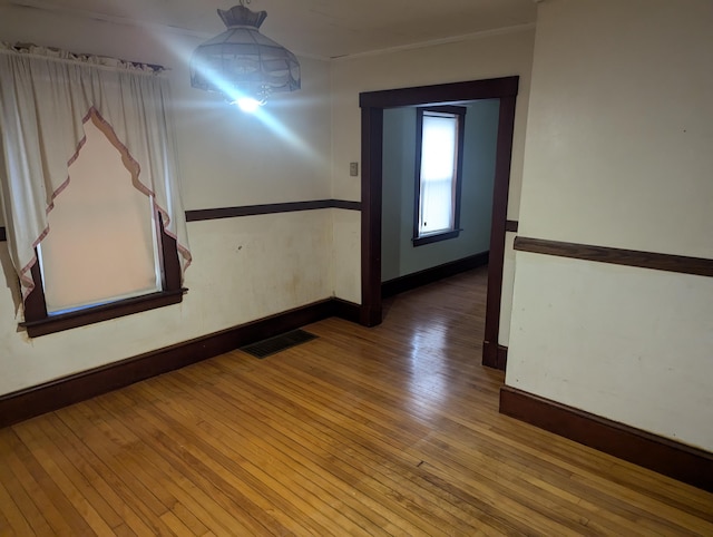 corridor featuring hardwood / wood-style flooring, baseboards, and visible vents