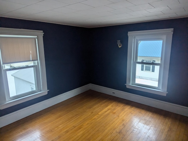 empty room featuring baseboards and hardwood / wood-style floors