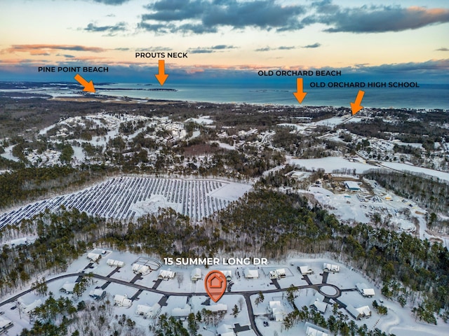 snowy aerial view featuring a water view