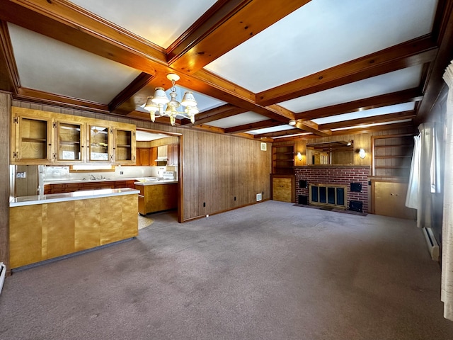 unfurnished living room featuring coffered ceiling, an inviting chandelier, a fireplace, and beam ceiling