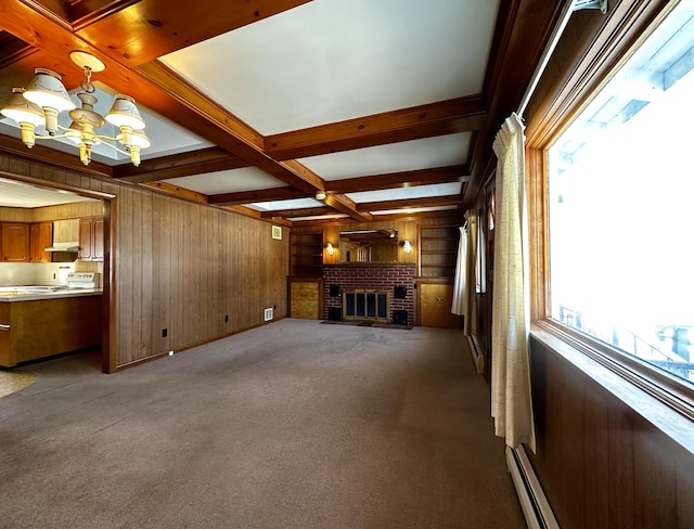 unfurnished living room featuring beam ceiling, plenty of natural light, wooden walls, and a chandelier